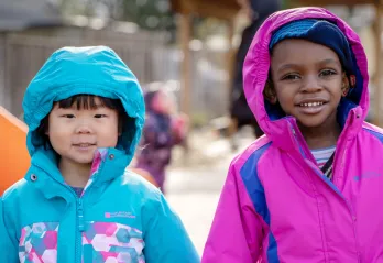 Two smiling girls playing outside 