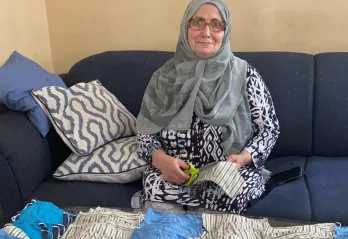 Afiyat, a skilled tailor, sews masks for the community.