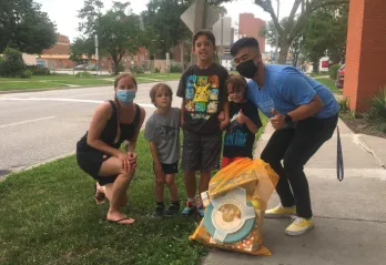 A family with three boys smile and pose with their Kids Club Kit.