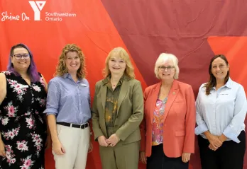 Five women infront of Y banner
