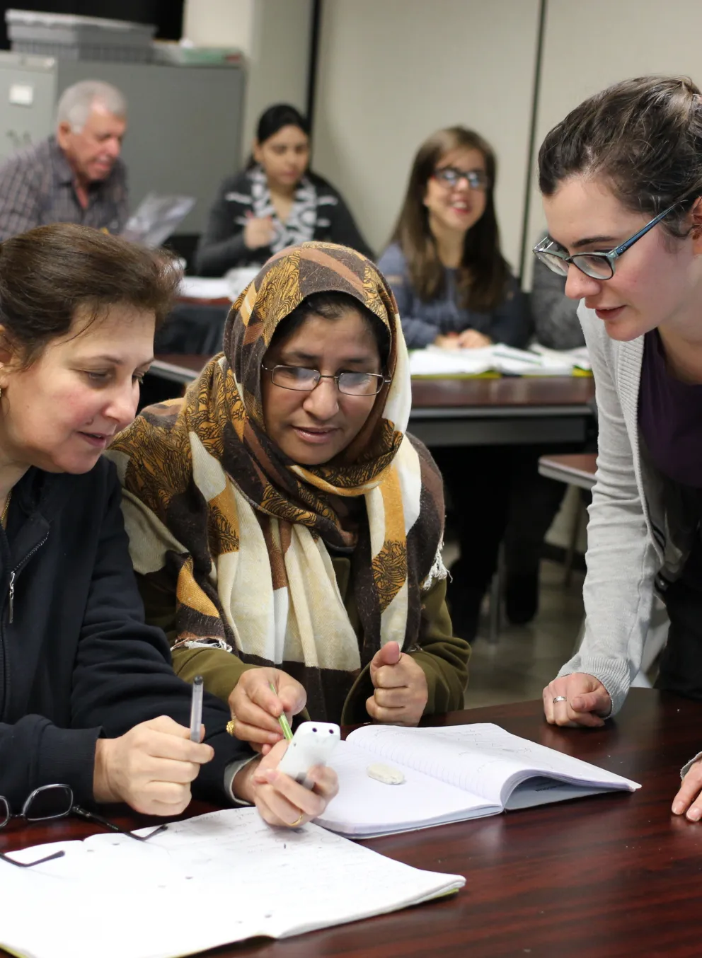 Newcomer ladies learning in class with teachers help