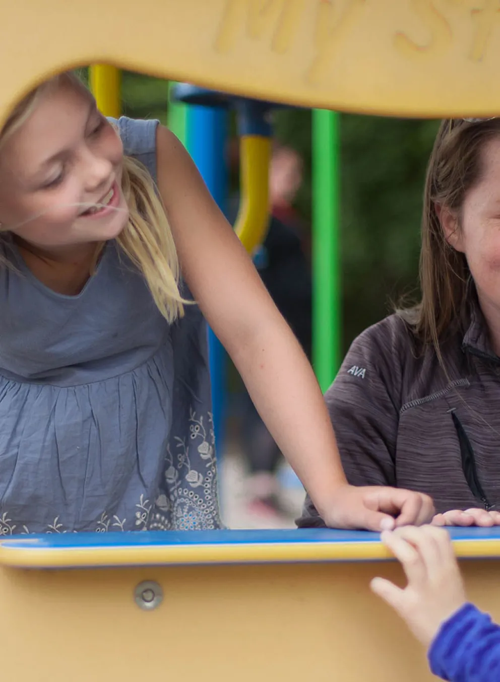 School Age Kids playing outside and interacting with a YMCA Staff member.