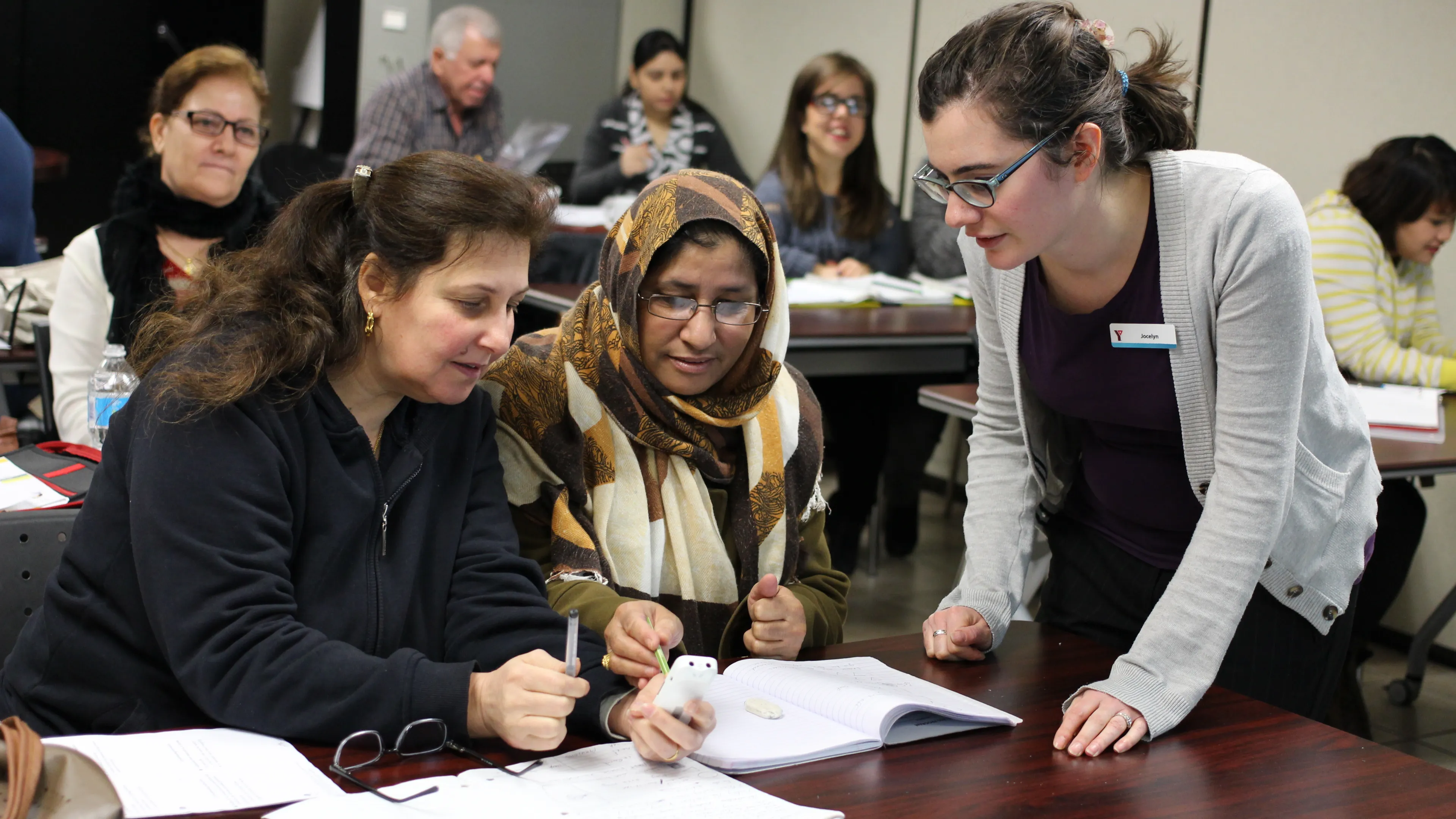 Newcomer ladies learning in class with teachers help
