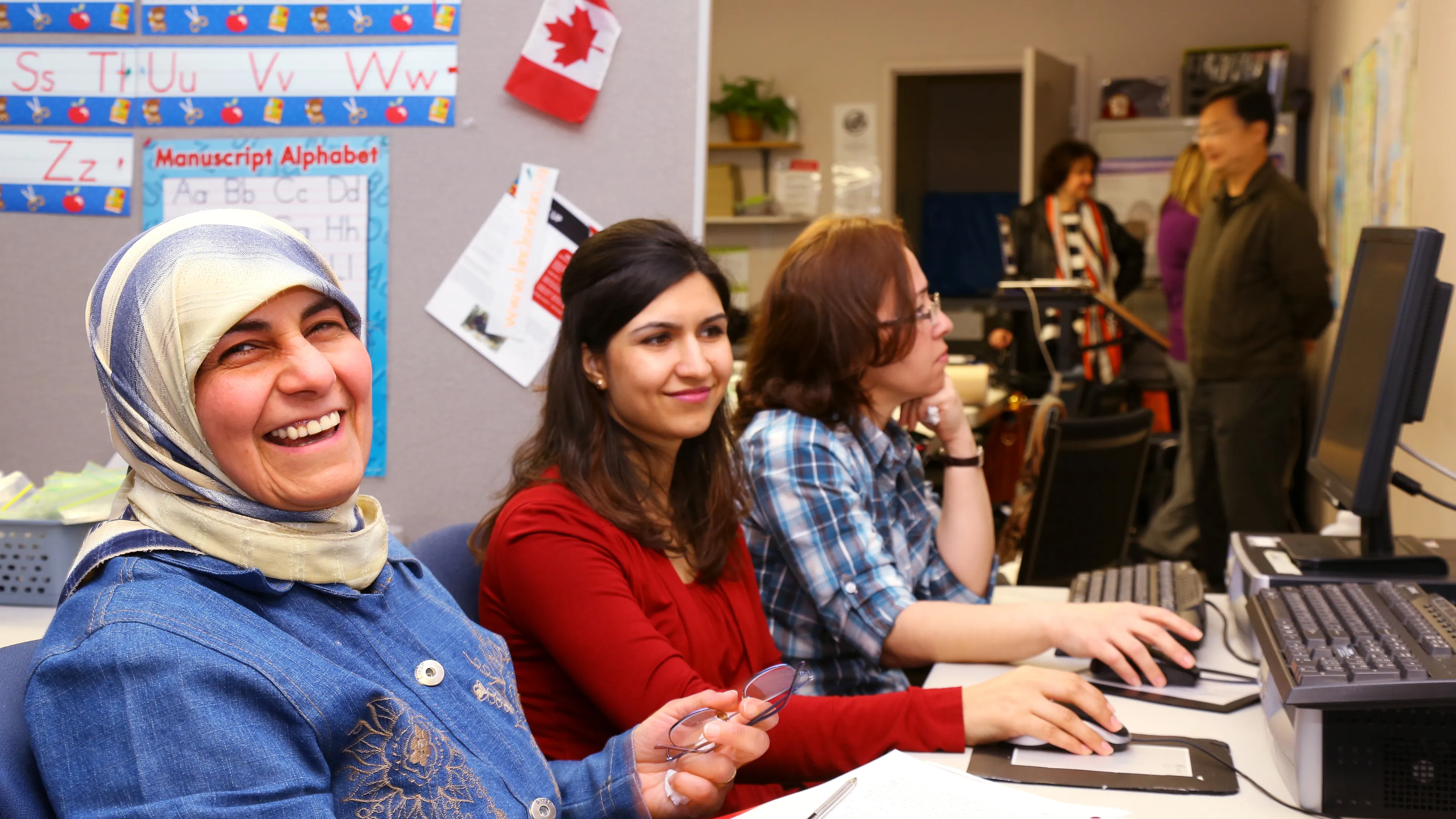 Newcomer ladies learning on computers
