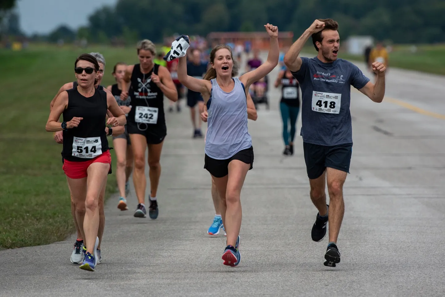 Runners celebrate with hands in the air as they participate in Jordan's Run The Runway.