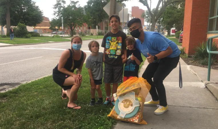 A family with three boys smile and pose with their Kids Club Kit.