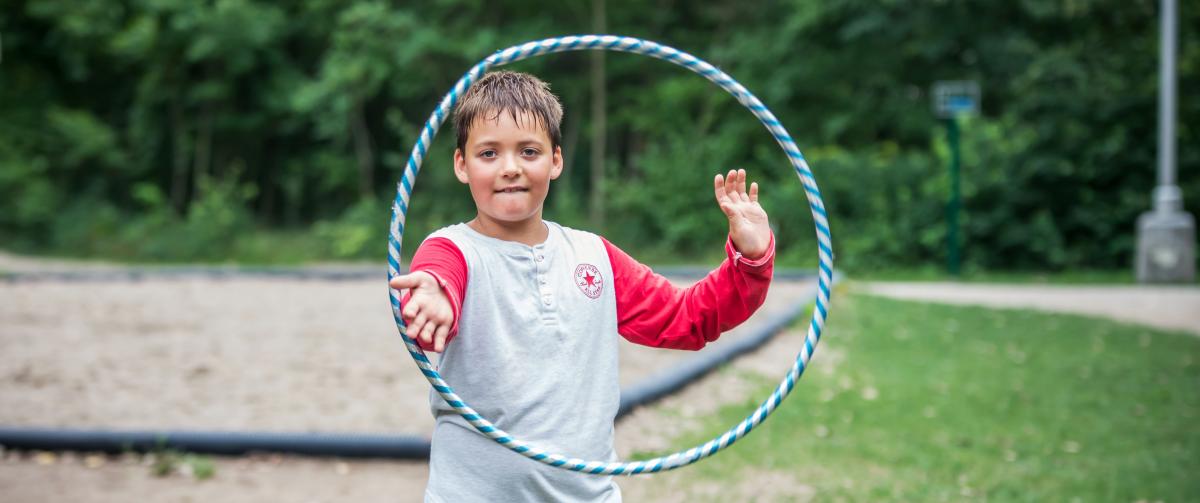 Camper playing with a hoola-hoop outside at Camp Henry