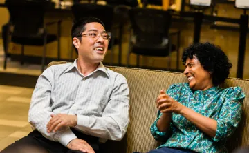 A man and woman sit together, laughing and talking.