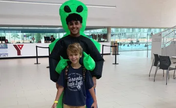 Daniil smiles and poses with a day camp counsellor in costume at the StarTech.com YMCA.