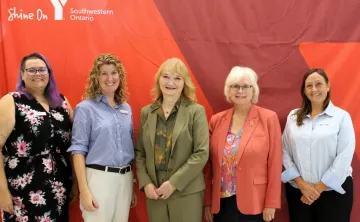 Five women infront of Y banner