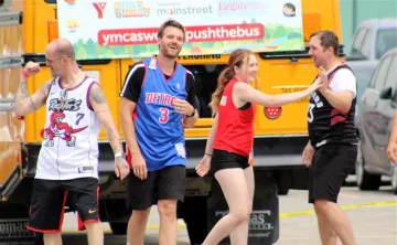 Team high fives in front of bus